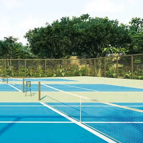 Tennis courts beside green woodland at Aparna Sunstone